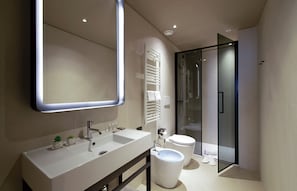 A modern bathroom with a large mirror, two sinks, a toilet, and a glass shower enclosure. - Scarlatti Hotel Milano (Milan)
