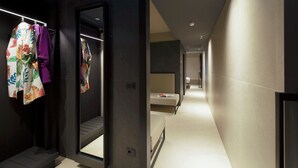 A modern hotel corridor with a mirror reflecting the interior, a bed, and a bathroom visible in the distance. - Scarlatti Hotel Milano (Milan)
