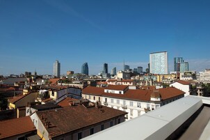 Paisagem urbana com mistura de edifícios modernos e tradicionais, incluindo um arranha-céu imponente.