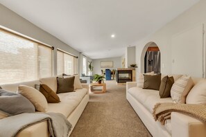 A modern living room with two sofas, a coffee table, and a fireplace. - Game Room Adventures : A Family-Friendly Getaway! (Arvada)