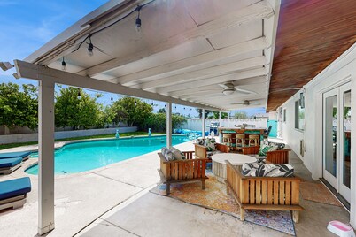 Modern retro-style home w/ game room, heated pool, large yard & covered patio
