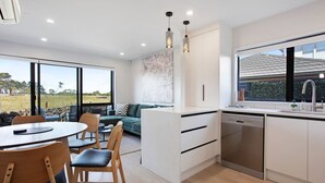 Una cocina moderna con comedor, ventanas amplias y vistas al exterior.