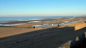 A beach with a clear sky, sandy shore, and a few people walking. - Vacation home, 300M BEACH (CABOURG town center)-6 people, 3 bedrooms (Cabourg)