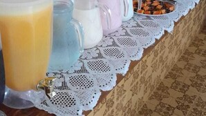 A buffet setup with various food items and beverages. - Villaggio di Roma Suítes  (Campos do Jordao)