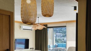 Ein modernes Hotelzimmer mit Essbereich, Fernseher und einem Balkon mit Stadtblick.