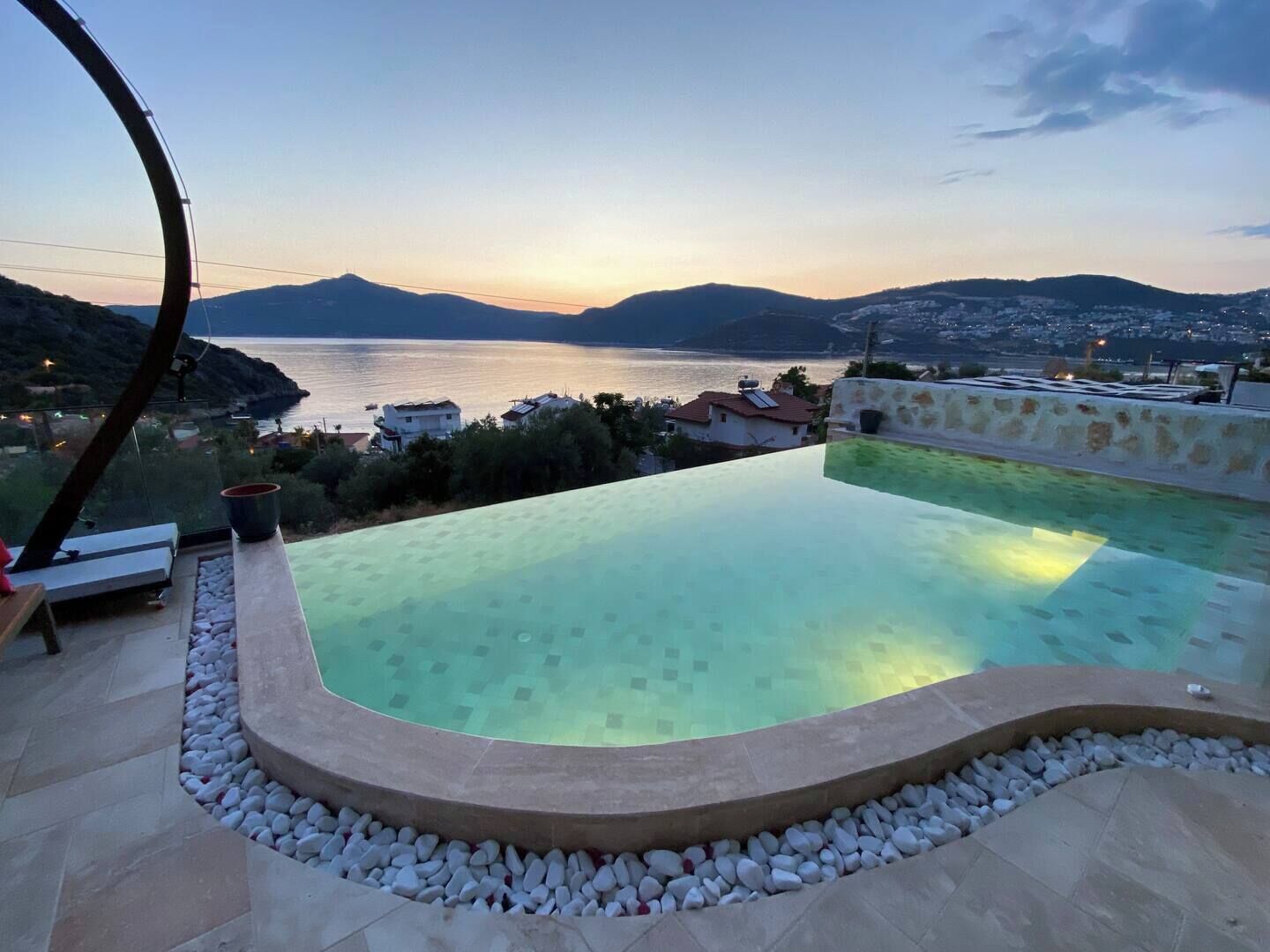 Uma piscina infinita com vista para o mar e as montanhas.