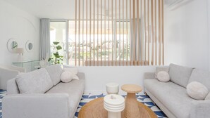 A modern living room with a sofa, a coffee table, and a window with vertical blinds. - Ocean Studio by ENDLESS SUN  modern comfort seaview WiFi parking rooftop pool (Lagos)