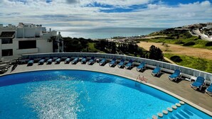 A swimming pool with lounge chairs and a view of the sea and buildings. - Ocean Studio by ENDLESS SUN  modern comfort seaview WiFi parking rooftop pool (Lagos)