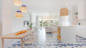 A modern kitchen with a dining area, white cabinetry, and a patterned floor. - Ocean Studio by ENDLESS SUN  modern comfort seaview WiFi parking rooftop pool (Lagos)