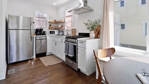 Una cocina compacta con refrigerador, estufa, microondas y armarios de madera.