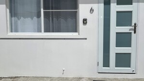 A white building with a window and a door. - Sea Breeze Tunnel Hideaway 7 (Quebradillas)