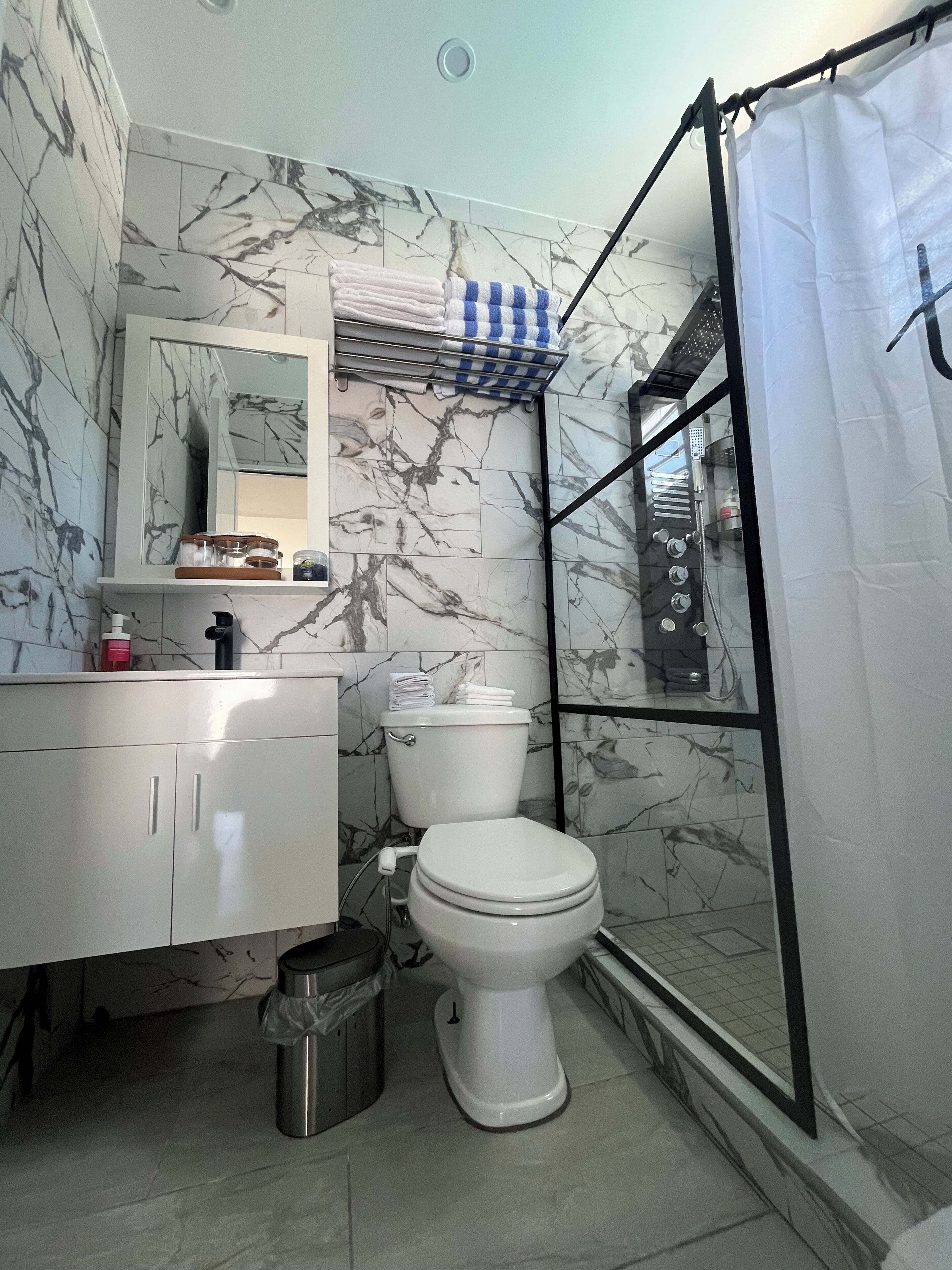 A bathroom with a toilet, sink, and shower area.