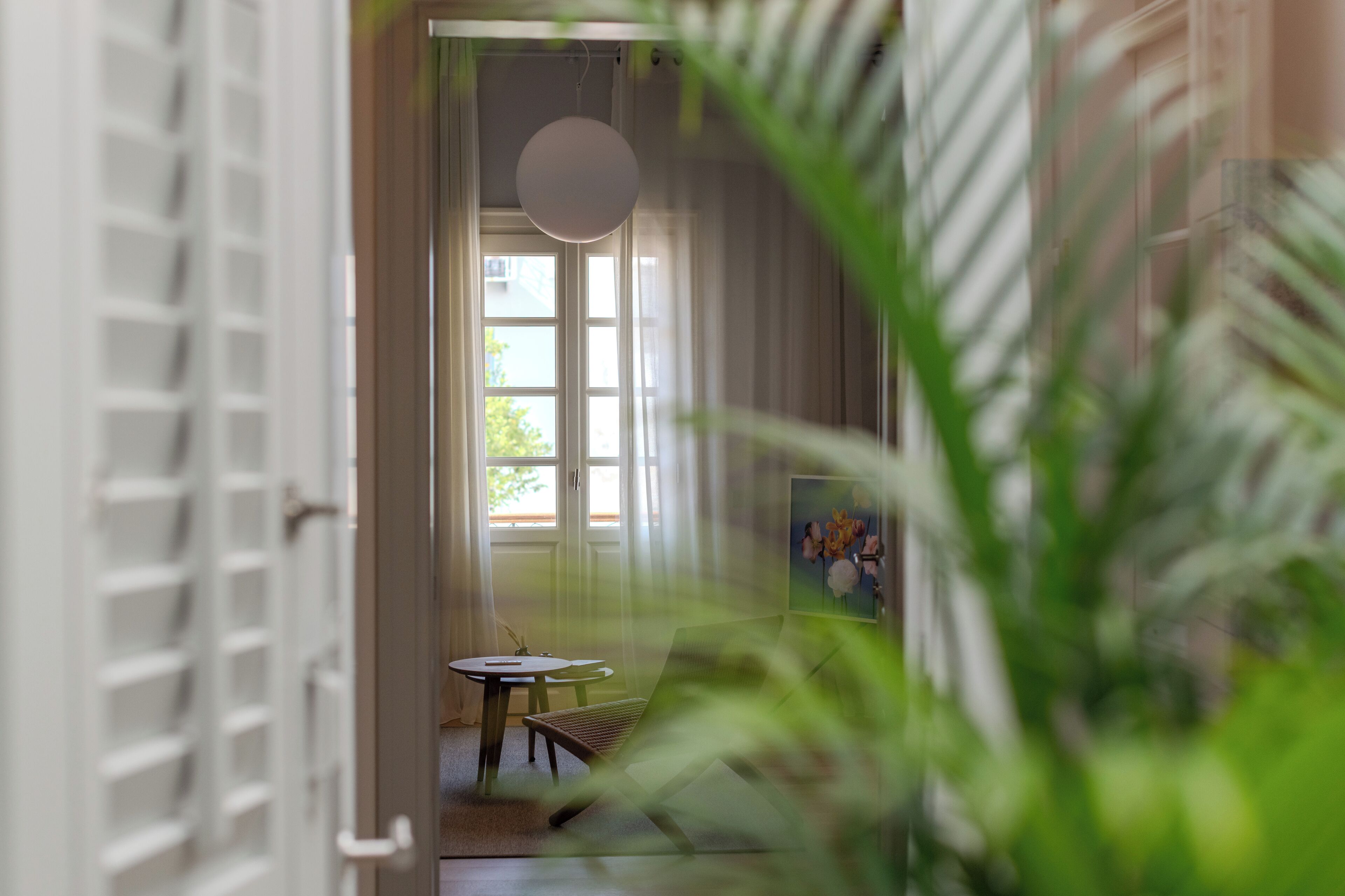 A room with a large window, a round table, and a chair.