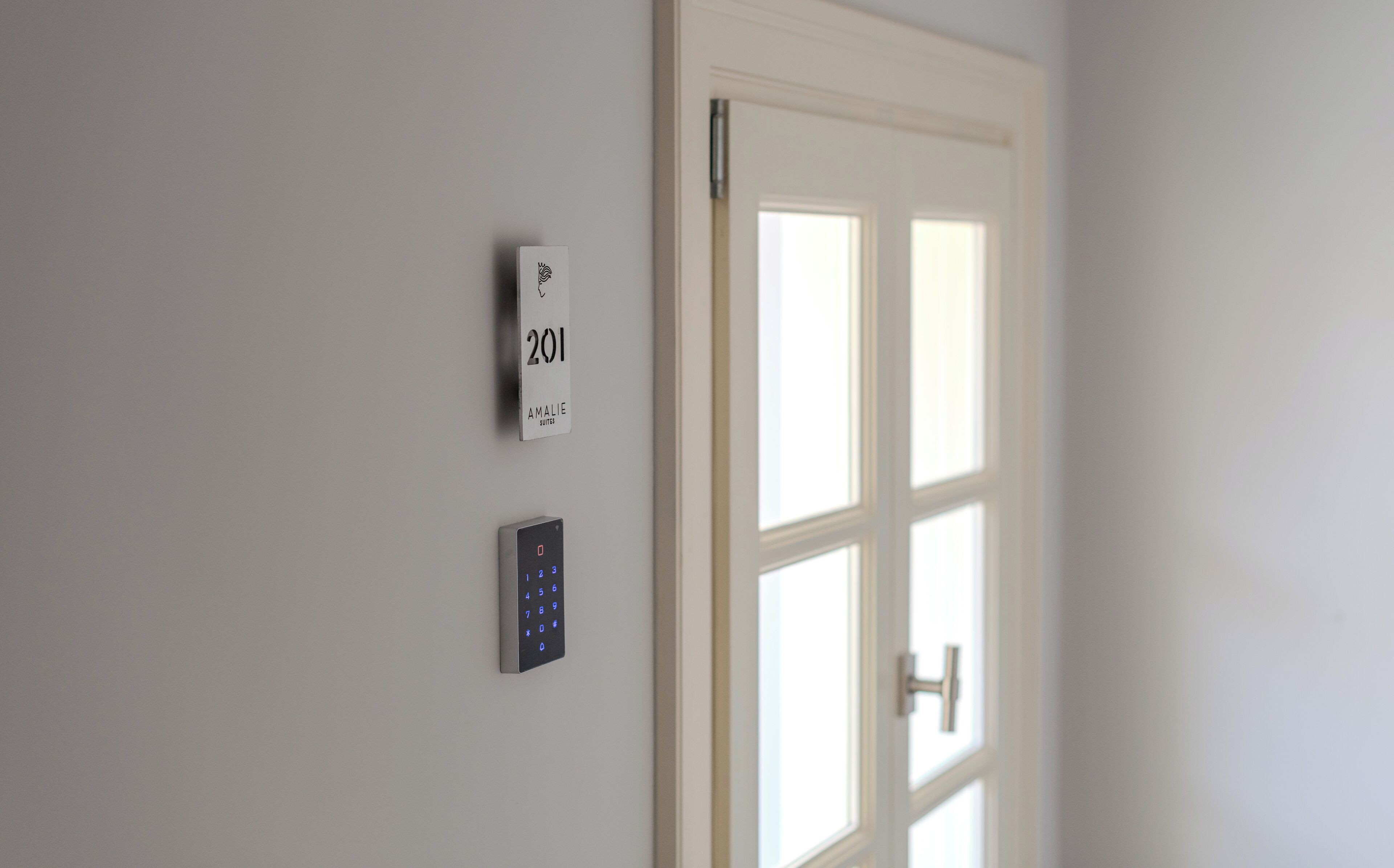 A door with a keypad lock and a sign above it indicating room number 201.