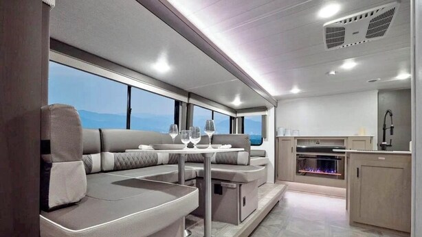 A modern RV interior with a dining area, seating, and a kitchen. - Cozy 2-bedroom RV in Serene Jerusalem with WiFi, AC, and plenty space to sleep (Jerusalem)