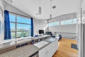 Enjoy meal preparation at the large island with sink and ample counter space, or relax in the cozy seating area with sofa and flat-screen TV.