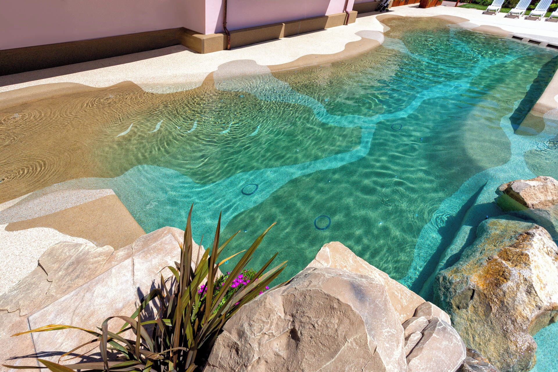 Una piscina cristalina rodeada de rocas y plantas.