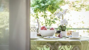Une table dressée avec un bol blanc, des tasses et une petite plante en pot.