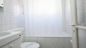 Un baño con inodoro, lavamanos y bañera.