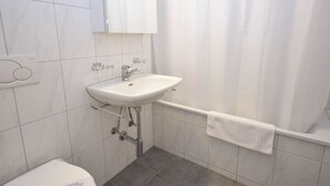 A bathroom with a white sink, a mirror, and a shower curtain.