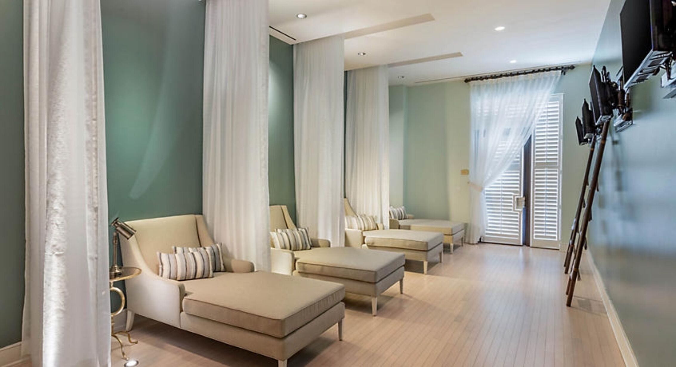 A modern hotel room with a large bed, two sofas, and a seating area with a small table.