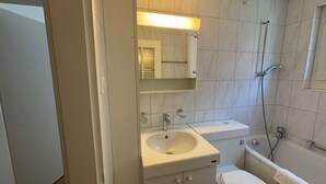 A bathroom with a sink, toilet, and bathtub.