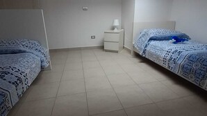 A bedroom with two beds, a nightstand, a lamp, and a skylight. - 5 minutes walk from the beach - New Apartment with 2 bedrooms in Italy (Giulianova)