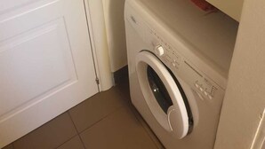 A compact laundry room with a washing machine and a cabinet above it. - 5 minutes walk from the beach - New Apartment with 2 bedrooms in Italy (Giulianova)