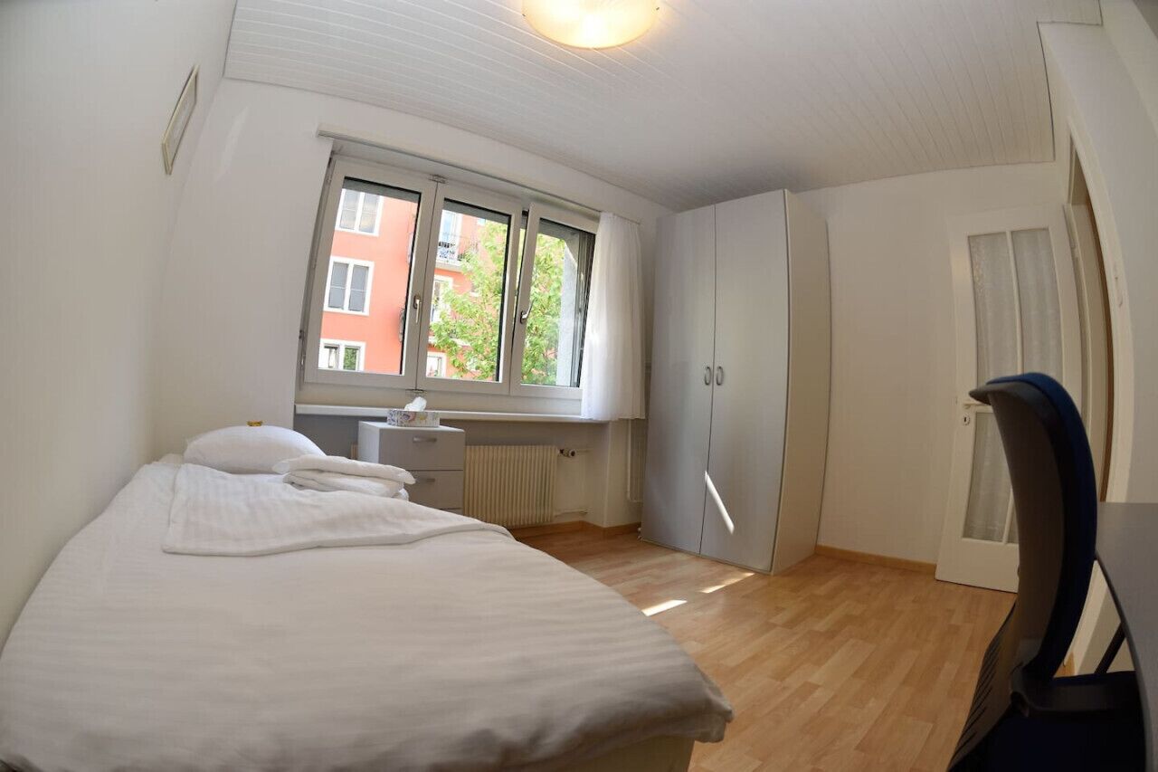 Ein Schlafzimmer mit einem Bett, einem Schreibtisch und einem Kleiderschrank.