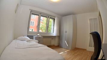 Ein Schlafzimmer mit einem Bett, einem Schreibtisch und einem Kleiderschrank.