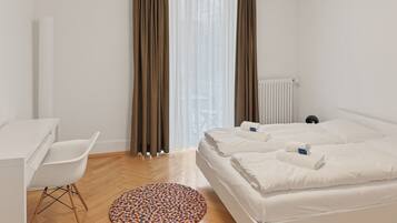 A bedroom with a bed, a desk, and a chair.