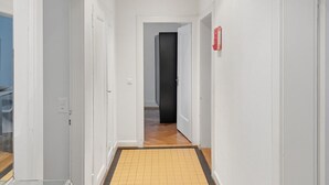 A hallway with white walls, a tiled floor, and a door leading to another room. - 2BR near lake (Stardust 11) (Zürich)