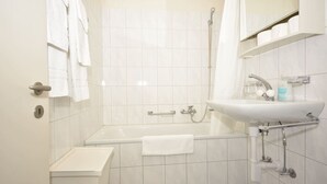 A modern bathroom with a bathtub, a sink, and a shower.