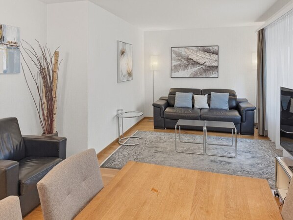 A modern living room with a sofa set, a coffee table, and a TV.