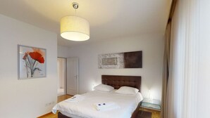 A hotel room with a large bed, a headboard, a bedside table, and a painting on the wall. - Executive 1BR flat, city center (Hammer 1) (Zürich)