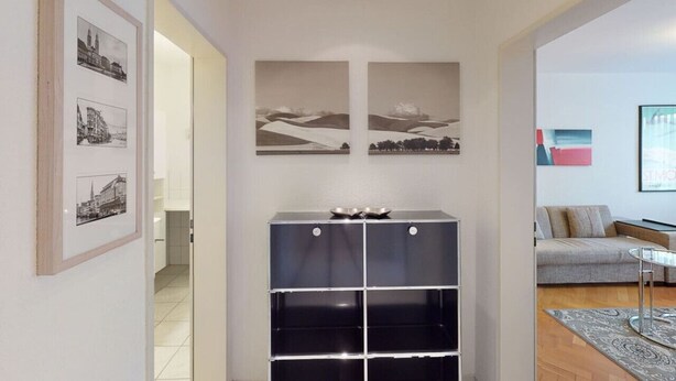 A modern living room with a sofa, a coffee table, and a black shelving unit with a bowl on top. - Executive 1BR flat, city center (Hammer 1) (Zürich)