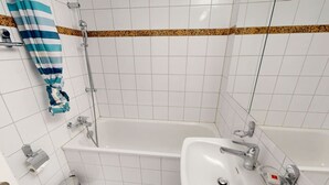 Un baño con bañera, lavamanos e inodoro.