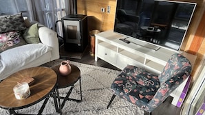 Un salon confortable avec un canapé, une table basse, un téléviseur et une cheminée.