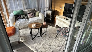 Un salon confortable avec un canapé, une table basse, un téléviseur et une cheminée.