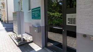 A building entrance with a sign for 'Zentrum für Naturopathie' and a glass door.