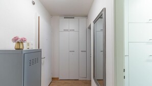 A narrow hallway with a grey wardrobe, a white wardrobe, and a mirror on the right. - Amazing studio (37 sqm) city center/Enge (Wille 4) (Zürich)