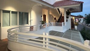 A two-story building with a white exterior, a red-tiled roof, and a balcony with a white railing. - Le Huynh Mui Ne Hotel (Mui Ne)