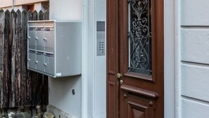 A building with a wooden door, a mailbox, and a mailbox unit on the wall. - Penthouse flat in the city center/near lake (SF18) (Zürich)