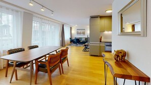 Ein modernes Wohnzimmer mit Essbereich, einer Küche und einem großen Fenster.