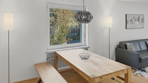 A modern living room with a wooden table, bench, and a grey sofa. - Beautiful, quite and very central 2BR flat (Sky6) (Zürich)