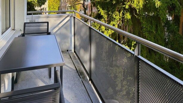 A balcony with a metal railing, a table, and chairs. - Beautiful, quite and very central 2BR flat (Sky6) (Zürich)
