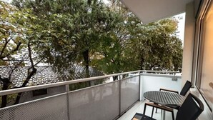 A balcony with a mesh railing, a round table, and two chairs. - Fantastic 2BR in the city center (Sky7) (Zürich)