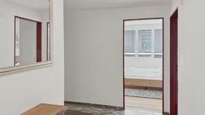 A hallway with a wooden bench, a mirror, and a bed with a wooden headboard. - Amazing 2BR flat: spacious and central (Duke2) (Zürich)