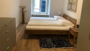 A bedroom with a bed, a dresser, a window, and a painting on the wall. - Fantastic 2BR flat close to Paradeplatz (Canal2) (Zürich)