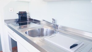 A modern kitchen with stainless steel appliances, a double sink, and a built-in oven. - Charming studio in the city centre (Art 14) (Zürich)